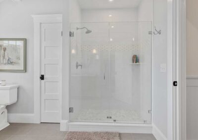 walk in shower in a pristine white bathroom